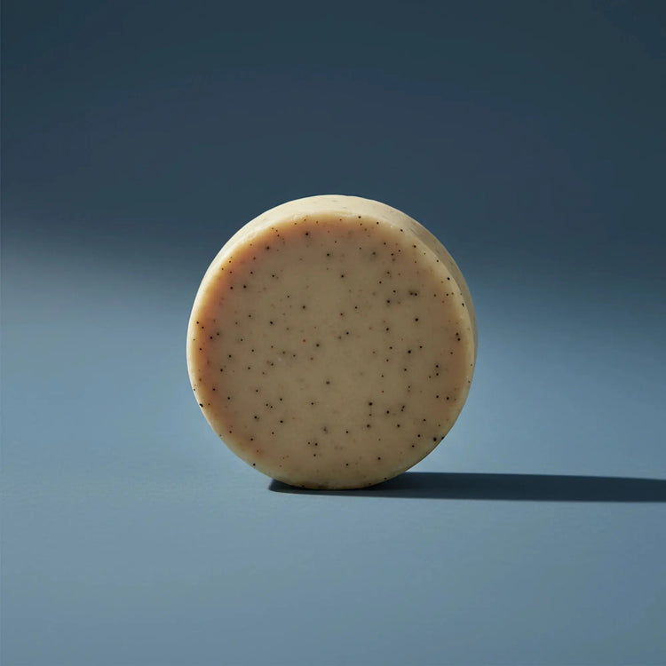 Beach Rain | Grass Fed Tallow | Shampoo Bar Blind Pirate Soap Co. a gorgeous, round and tan shampoo puc stands on it's side.
