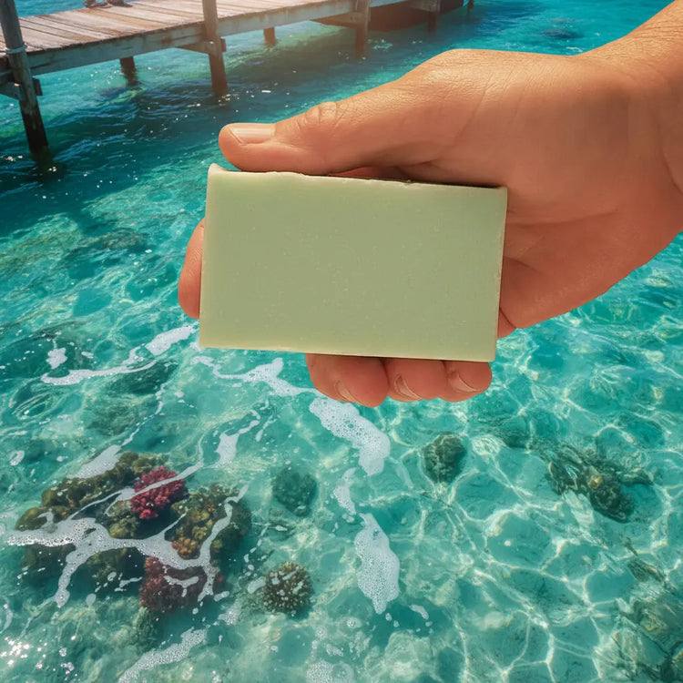 Spearmint Reef natural tallow soap bar by Blind Pirate Soap Company — smooth pale mint bar held in hand against a crystal turquoise ocean reef backdrop.