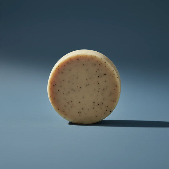 Beach Rain | Grass Fed Tallow | Shampoo Bar Blind Pirate Soap Co. a gorgeous, round and tan shampoo puc stands on it's side.   