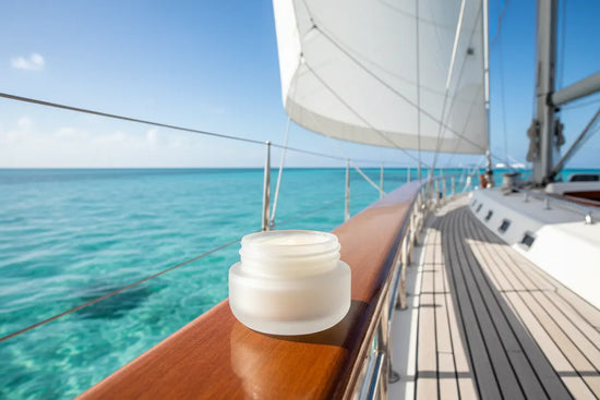 Ditch Kit lip balm on a sailing yacht rail with Caribbean turquoise water and white sails. Blind Pirate Soap Co.