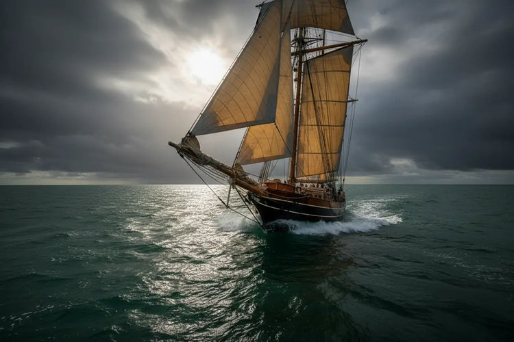 A majestic sailboat bears down through stormy seas, its silhouette eclipsing the last pale sun in a dramatic sky.