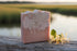 Naked bar — swirl top, driftwood Unwrapped Honeysuckle soap bar showing sculpted pink and cream swirl top, honeysuckle blossoms alongside.