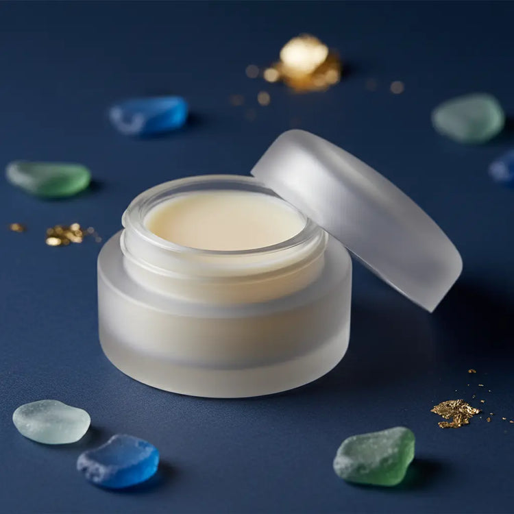 Close-up of frosted glass jar showing pale ivory clear lip balm surface