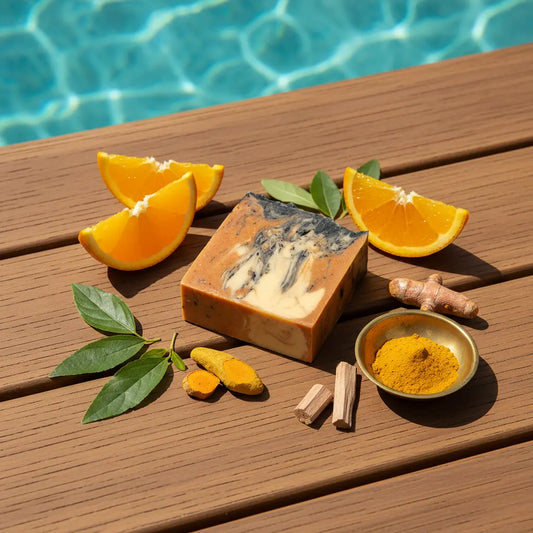 Unwrapped Orange Crush tallow soap bar and fresh sliced oranges on a sun-warmed teak pool deck, turquoise infinity pool glistening.
