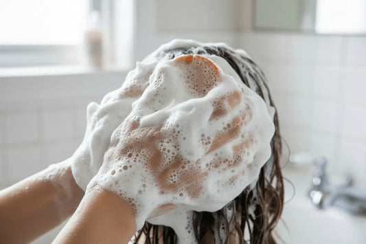 Orange & Honey - Honeycomb & Oranges Orange and honey shampoo bar  being used to shampoo a persons hairs
