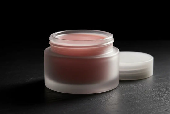 Ditch Kit rose tinted lip balm in frosted glass jar, lid off, soft pink tallow balm on dark marble. Blind Pirate Soap Co.