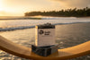 Surfer Suds tallow soap bars stacked on lacquered wood, glowing in golden light on the legendary surf beach of Nias, Indonesia