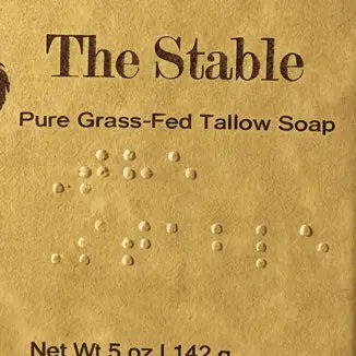 The Stable Braille label close-up — pirate logo, title, and full Braille block on artisan paper. Blind Pirate Soap Co.